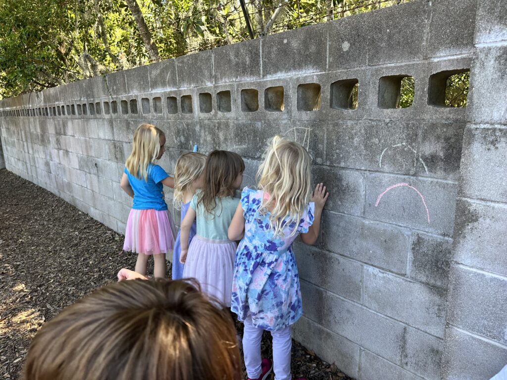 IMG_9094 three girls drawing on an outside wall with chalk