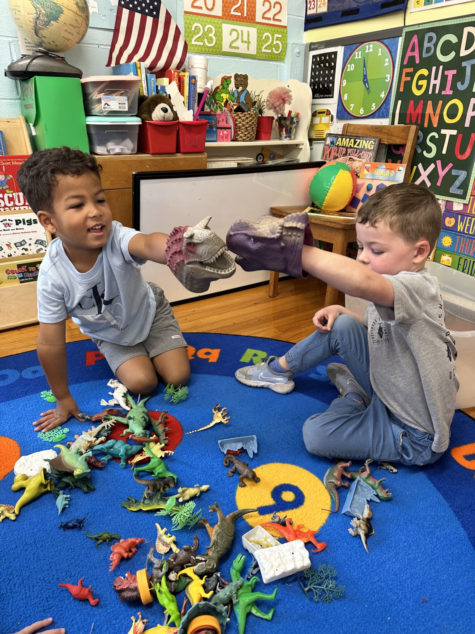 two four year old boys playing iwth dinosaur toys and puppets